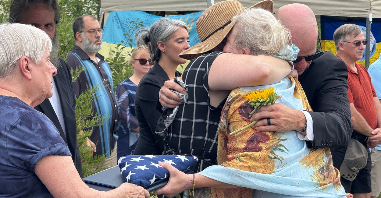 The family of Robert "Bobby" Pietrangelo hugs tight as his mother clasps a folded American flag.