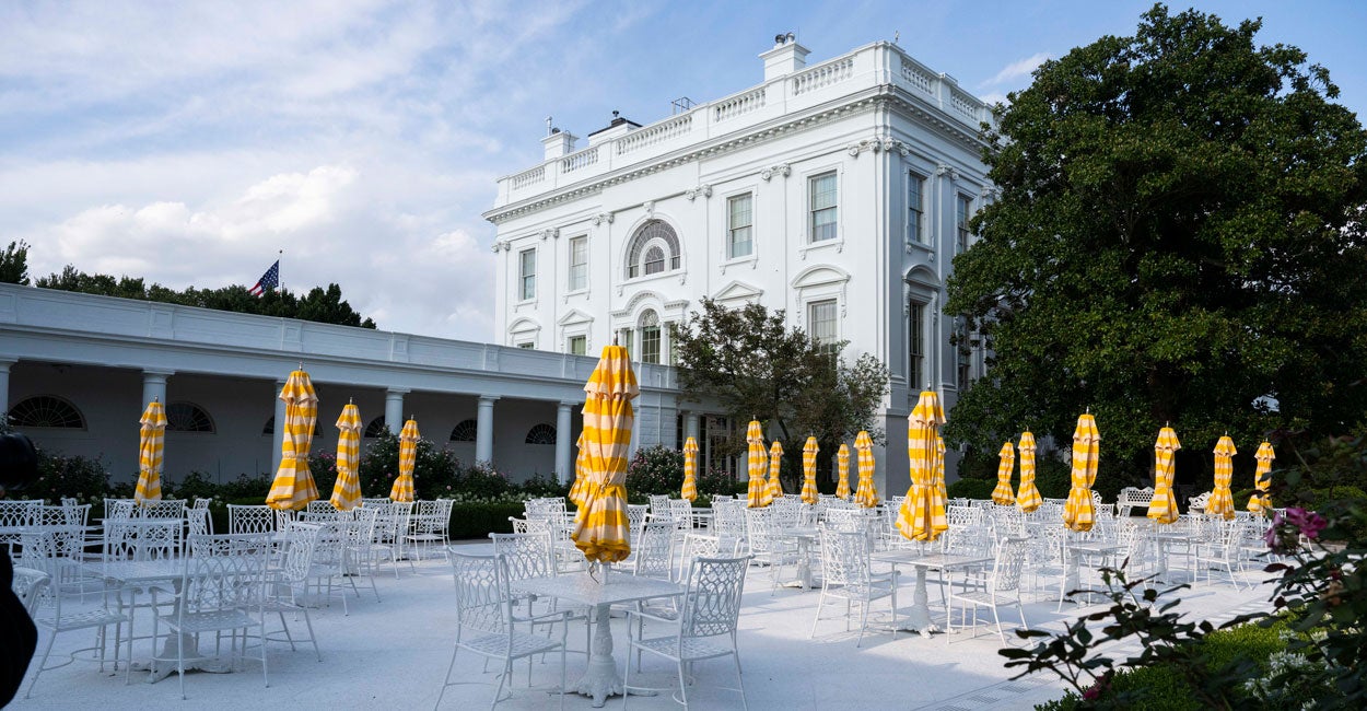 The renovated Rose Garden is shown with tiles covering the grass and tables with umbrellas on top of them.