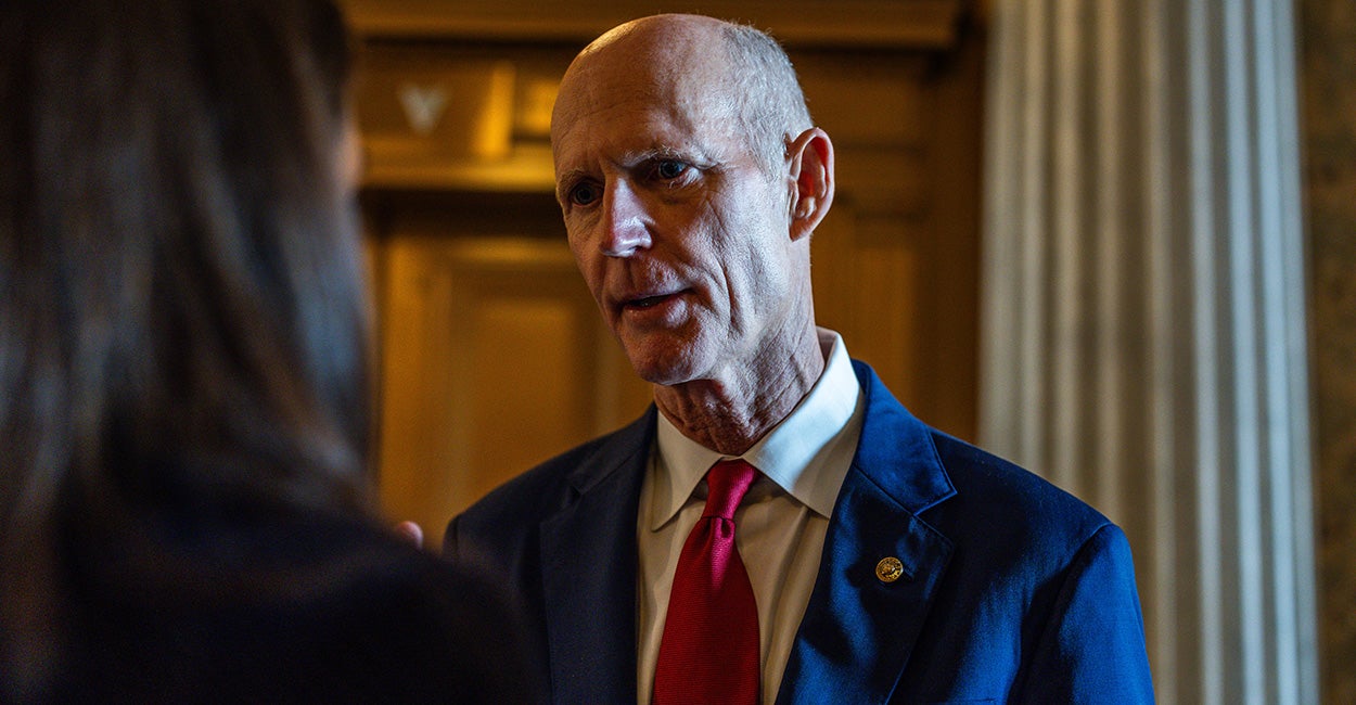 Senator Rick Scott sits in a committee room in the capitol.